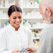 Pharmacist behind the counter talking to a customer