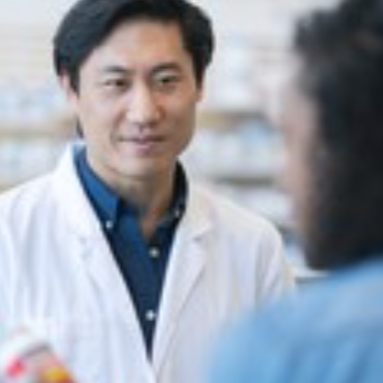 Pharmacist handing pills to a customer